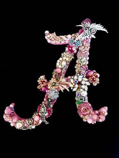 the letter f is made up of many different types of beads and jewels on it