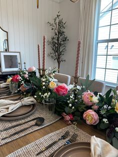 the table is set with flowers, candles and place settings for two people to sit at