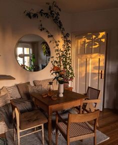 a living room filled with furniture and a mirror on the wall above it's door