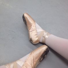 two pairs of ballet shoes that have been worn by someone on the dancefloor