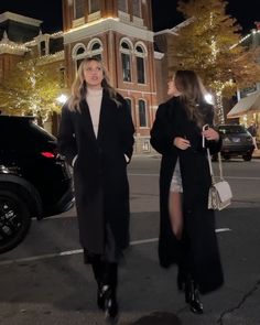 two women walking down the street at night