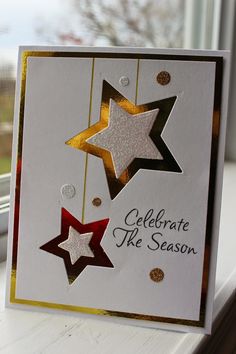 a card with three stars hanging from it's side on a window sill