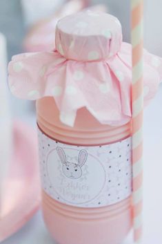 a baby shower bottle with a pink bow on it's cap and a striped straw