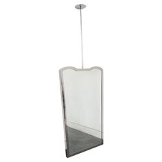 a large mirror hanging from the ceiling with a light fixture on it's side