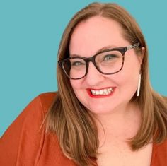 a woman with glasses is smiling for the camera while wearing an orange shirt and brown cardigan