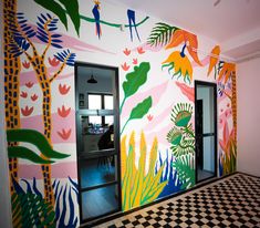 an office decorated with brightly colored murals and black and white checkered flooring,