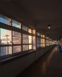 an empty hallway with lots of windows on both sides