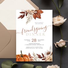 the thanksgiving dinner party is set on top of a table next to flowers and an envelope