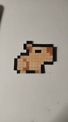 a piece of wood cut out to look like an old video game character on a white surface