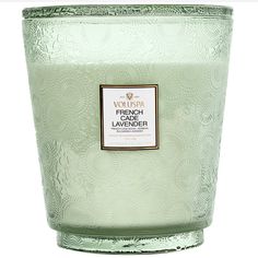 a green glass candle with a label on it