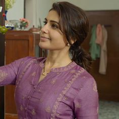 a woman standing in front of a refrigerator