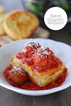 a white plate topped with meatballs covered in marinara sauce and parmesan cheese