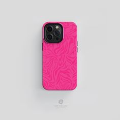 a pink phone case sitting on top of a white surface with an animal print pattern