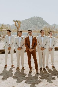 a group of men standing next to each other in front of a desert mountain range