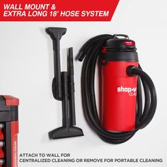 a red and black vacuum is next to a wall mount and extra long hose system