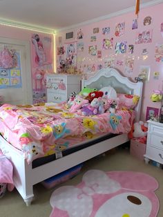 a bedroom decorated in pink and white with hello kitty decorations on the walls, rugs and bedding