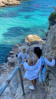 two people walking up some steps near the water