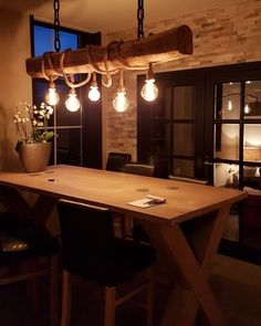 a wooden table with lights hanging from it