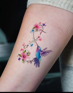 a colorful humming bird tattoo on the arm