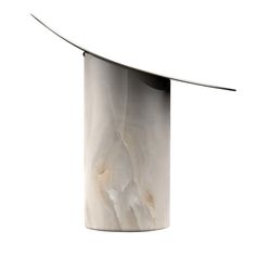 a white and black vase sitting on top of a table next to a metal object