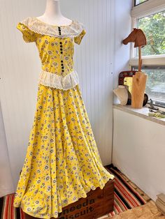 Oh this gorgeous canary yellow gown is so unique and perfect for so many occasions.  Bright yellow cotton dress with black and white novelty daisy motifs sprinkled throughout piece. White eyelet cotton ruffles on collar and waistline - giving it a peplum fit - with 3 rows of plastic black buttons, all intact. There is cinching at the sides to give this a more fitted look at the waist - not sure if this was added in later - but the stitching is concise to the age. Cotton has a gorgeous weight to it and feels lightly textured, a la feed sack style. Perfect representation of the time period while also being an incredibly unique and timeless piece. In good vintage condition - visible flaws shown in last two pics.  Measurements -  Pit to pit: 17.5"   Bust: 31" Waist: 27"   Hips: 54" Length: 56. Feedsack Dress, Yellow Cotton Dress, Granny Dress, Yellow Gown, Canary Yellow, White Eyelet, Daisy Print, Day Dress, Dress Vintage