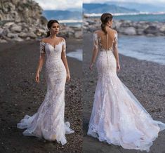 two women in wedding dresses standing on the beach, one wearing an open back dress