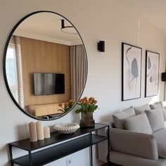 a living room filled with furniture and a large round mirror