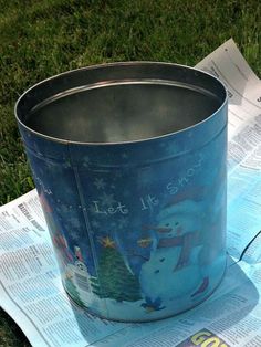 a metal bucket sitting on top of a paper towel next to a cup with a snowman design