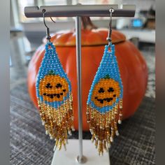 a pair of beaded pumpkin earrings sitting on top of a table