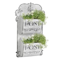 two metal wall mounted planters with plants growing out of the letters on each side