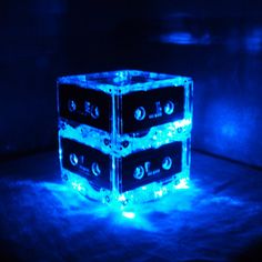 three cubes that have been made out of plastic and are lit up with blue lights