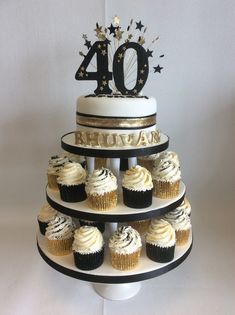 a tiered cake with cupcakes on it and the number forty birthday cake topper