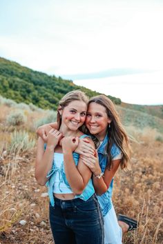 two girls hugging each other in a field