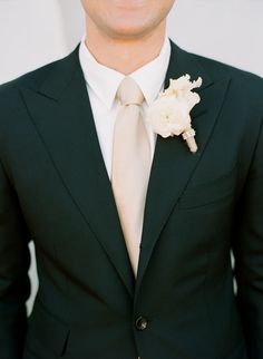 a man in a suit and tie with a flower on his lapel pinhole