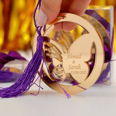 a person holding onto a purple and gold ornament