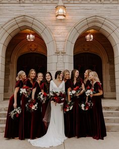 a group of women standing next to each other in front of a building with red and white bouquets