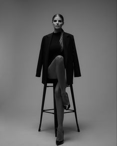 a woman sitting on top of a chair with her leg up in front of her