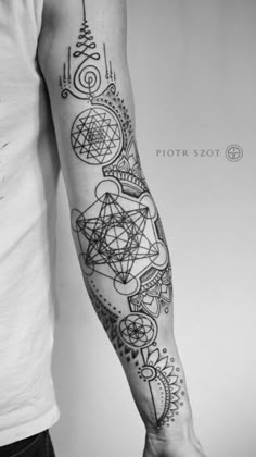 a man's arm with tattoos on it and an intricate design in the middle