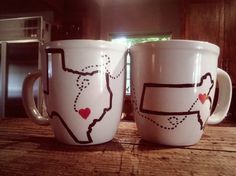 two white coffee mugs sitting on top of a wooden table