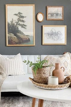 a living room with pictures on the wall and a white couch in front of it