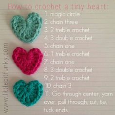 three crocheted hearts sitting on top of a piece of paper with instructions for how to crochet a tiny heart