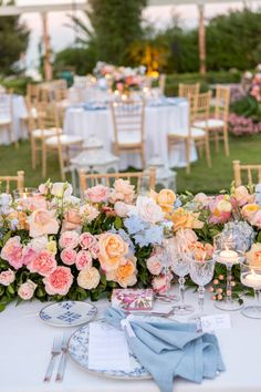 the table is set with flowers, candles and place settings for an elegant wedding reception