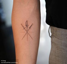 two crossed swords tattoo on the left inner forearm and arm, one with an arrow in it