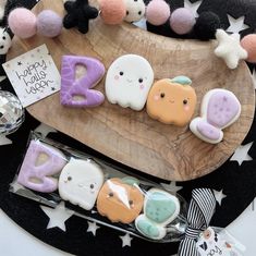 decorated cookies are sitting on a wooden platter next to other decorations and candies