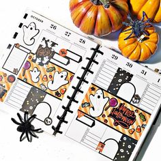 an open halloween planner with pumpkins and other decorations