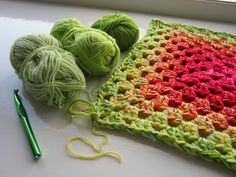 two balls of yarn are next to a crochet square