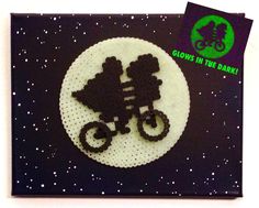 a crocheted brooch with an image of two people riding on a bike