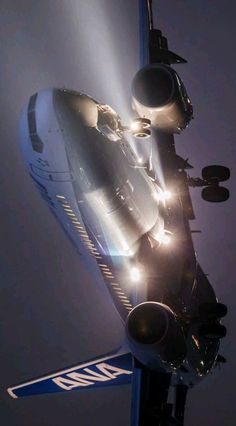 an airplane is flying in the sky with lights coming from it's engine and landing gear