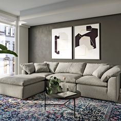 a living room with two paintings on the wall and a large couch in front of it