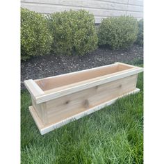 a wooden planter sitting in the grass